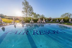 a swimming pool with chairs and a sign that reads all air resort at FAIR RESORT All Inclusive Wellness & Spa Hotel Jena in Jena +96 photos