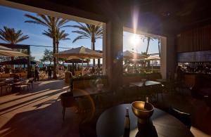 帕爾馬海灘的住宿－Universal Hotel Neptuno - Adults Only，一间设有桌椅的餐厅,种植了棕榈树