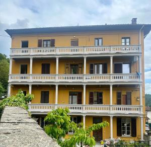a large yellow building with a balcony at Verso il Lago in Laveno-Mombello +3 photos
