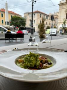 a white plate with a dish of food on a table at Albergo Florida Taggia in Taggia
