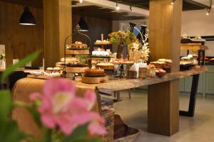 a buffet of food on a long table with pastries at Pousada Belluno in Gramado