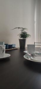 a table with plates and a potted plant on it at By The Sea in Asprovalta