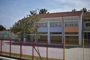 a building with a red fence in front of it at By The Sea in Asprovalta