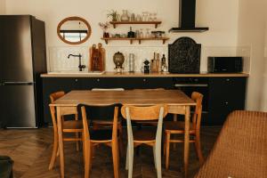 a kitchen with a wooden table and chairs at L'Atelier de Roger in Le Bourg-Dun
