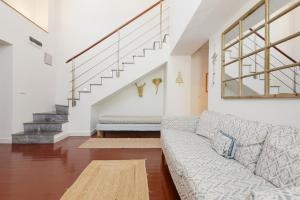 a living room with a couch and stairs at Rocamadour - Casa del Caminito in Málaga
