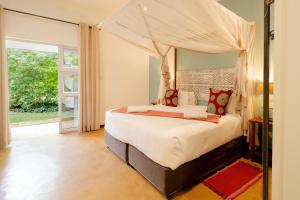 a bedroom with a bed with a canopy at PheZulu Guest Lodge in Victoria Falls