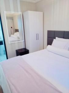 Schlafzimmer mit einem weißen Bett und einem Spiegel in der Unterkunft The Palace Flat Moema in São Paulo