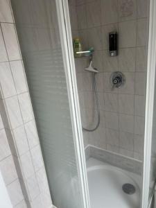a bathroom with a shower with a white tub at Erholung an der Nordsee in Wilhelmshaven +19 photos