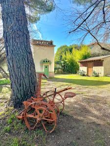 een verroeste bank naast een boom bij Écrin de nature , centre-ville et campagne, appart 2 chambres, grand jardin, en Provence verte in Brignoles