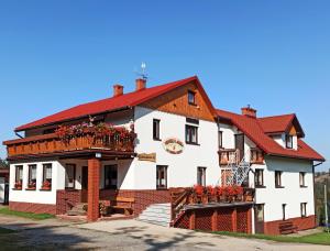 什切爾克的住宿－POKOJE GOŚCINNE U ANIELI，一座白色的大建筑,有红色的屋顶