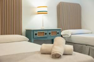 a room with two beds and a table with a lamp at Rocamadour - Casa del Caminito in Málaga