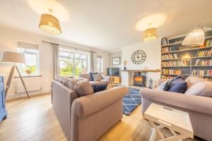 a living room with two couches and a fireplace at Spring Cottage in Burnham Market