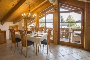 a dining room with a table and chairs and a large window at Golden GaPa Penthouse 1 in Garmisch-Partenkirchen