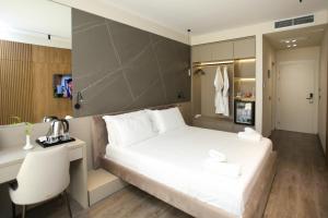 1 dormitorio con 1 cama blanca grande y escritorio en Charm Hotel en Vlorë