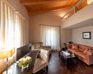 ein Wohnzimmer mit einem Sofa und einem Tisch in der Unterkunft Villa Pattono Relais in Costigliole dʼAsti