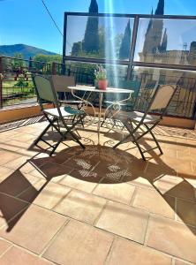 een patio met een tafel en stoelen op een balkon bij Écrin de nature , centre-ville et campagne, appart 2 chambres, grand jardin, en Provence verte in Brignoles