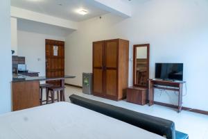 Habitación con cama, escritorio y TV. en Iddamal Apartments en Mount Lavinia