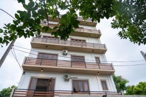 d'un grand bâtiment blanc avec balcon. dans l'établissement Iddamal Apartments, à Dehiwala-Mont Lavinia