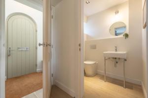 a bathroom with a white toilet and a sink at Kingfishers Cove in Titchwell +37 photos