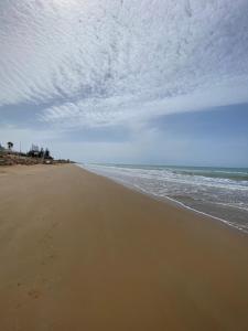 une plage vide avec un ciel nuageux et l'océan dans l'établissement Villino Oleandro, à Santa Maria Del Focallo