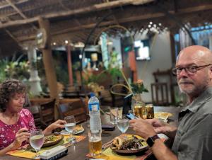 un homme et une femme assis à une table mangeant de la nourriture dans l'établissement VISU VILLA hotel, à Habarana