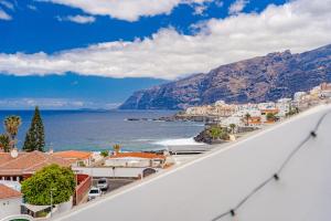 a view from a balcony of a city and the ocean at 2BDR Ocean View & Large PRIVATE Terrace in Puerto de Santiago in Puerto de Santiago