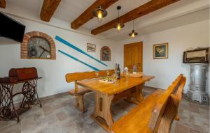 a dining room with a wooden table and benches at Beautiful Home In Prizna With Wifi in Prizna