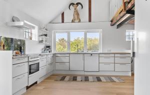 a kitchen with white cabinets and a large window at Pet Friendly Apartment In Vestervig in Vestervig