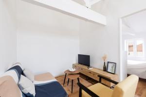 a white living room with a bed and a desk at Appartement climatisé 2 chambres in Villefranche-sur-Saône