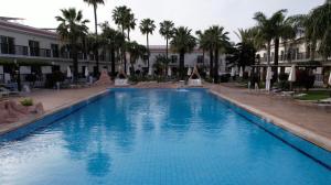 a large blue swimming pool next to a building at Loutsiana Deluxe Apts in Ayia Napa