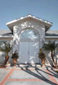 a house with a white door and two palm trees at Nice furnished Twin room #B in Stanton +9 photos