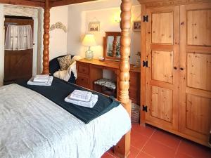 Schlafzimmer mit einem Bett, einer Kommode und einem Spiegel in der Unterkunft Laity in Polperro