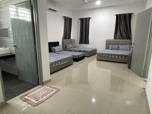 a living room with two beds and a couch at cuti-cuti port dickson homestay in Port Dickson