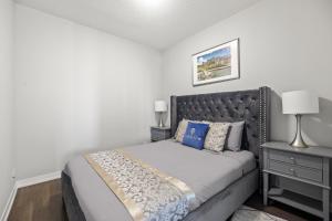 um quarto com uma cama grande e uma cabeceira preta em Modern Lillian St Apartments by GLOBALSTAY em Toronto