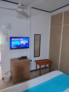 Un dormitorio con una cama y un televisor en la pared. en Ditshane Lodge, en Gaborone
