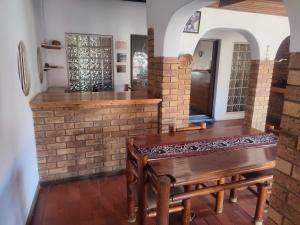 cocina con mesa de madera y pared de ladrillo en Ditshane Lodge, en Gaborone