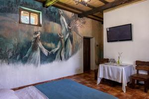 a room with a painting on the wall and a table at Resto Park Традиція in Podvorki