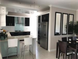 a kitchen with a black refrigerator and a table at Amani Luxe Villa in Amsterdamhoek