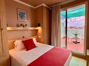 Hotel Piccadilly Sitges في سيتجيس: غرفة نوم بسرير ومنظر على فناء