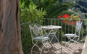due sedie e un tavolo di fronte a una recinzione di Hotel Santo Stefano a Portoferraio
