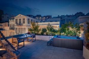 a rooftop patio with a view of a city at night at Ninemian Suites Syros in Ermoupoli