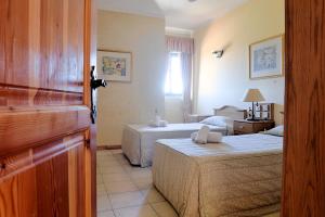 ein Hotelzimmer mit 2 Betten und einem Fenster in der Unterkunft Cornucopia Hotel in Xagħra