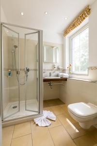 a bathroom with a shower and a toilet and a sink at Café Wildau Hotel & Restaurant am Werbellinsee in Schorfheide +45 photos