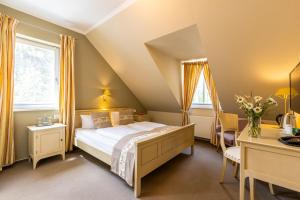 a bedroom with a bed and a desk at Café Wildau Hotel & Restaurant am Werbellinsee in Schorfheide