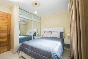 sypialnia z łóżkiem i dużym lustrem w obiekcie Oasis en la Sultana del Este w mieście San Pedro de Macorís
