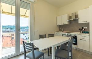 スカンディッチにある3 Bedroom Cozy Apartment In Scandicciのキッチン(テーブル、椅子付)、大きな窓が備わります。