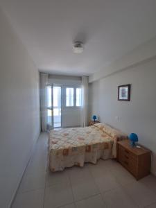 a bedroom with a bed and a dresser in it at Piso da Playa in Laxe