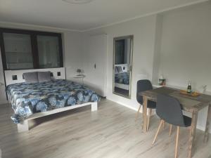 奥尔什丁Apartament Wierzbowa - Pod Orzechem的一间卧室，配有一张床和一张桌子和椅子