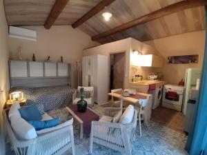a room with a bed and a table and a kitchen at La cabane d'Alcée in Vacqueyras
