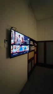 Gil's Home of Joy & Serenity في حيفا: تلفزيون بشاشة مسطحة معلق على الحائط